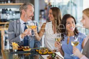 Happy business colleagues interacting and toasting beer glasses