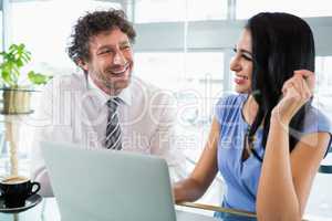Businessman discussing with colleague over laptop