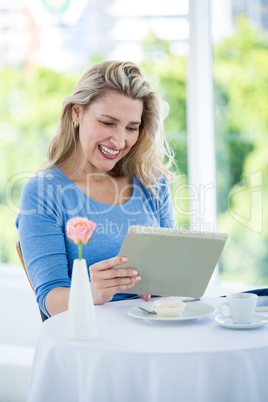 Happy mature woman using digital tablet