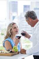 Happy mature couple holding red wine