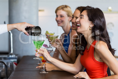Waiter pouring cocktail into cocktail glass