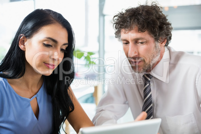 Businessman discussing with colleague over laptop