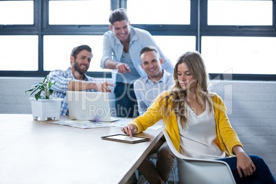 Male colleagues laughing on businesswoman