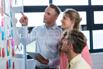 Businessman pointing while discussing with colleagues