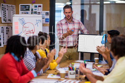 Businessman giving presentation to colleagues in office