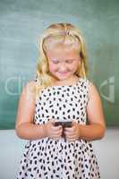 Schoolgirl using mobile phone in classroom