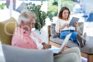 Woman using digital tablet while relaxing on seat