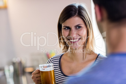 Woman looking at boyfriend while drinking beer