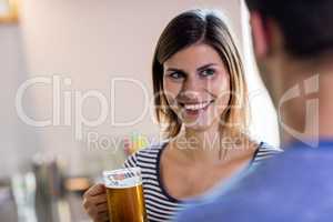 Woman looking at boyfriend while drinking beer