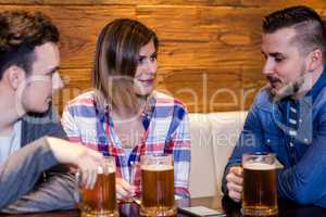 Happy friends with beer mugs in restaurant