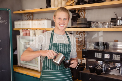 Waiter pouring coffee in a cup