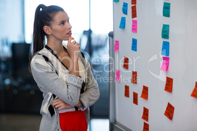 Woman looking at adhesive notes in office