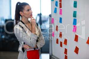 Woman looking at adhesive notes in office