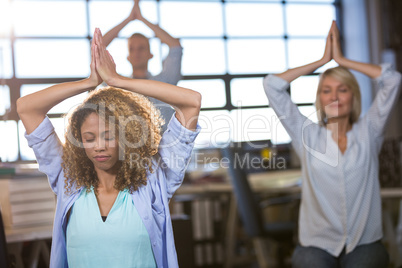 Creative business people practicing yoga