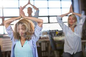Creative business people practicing yoga