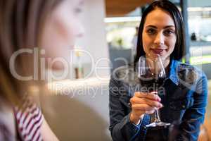 Beautiful woman drinking wine with friend