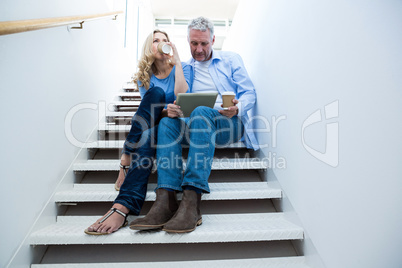 Man with woman holding digital tablet