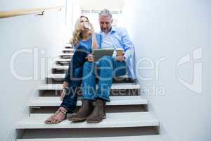 Man with woman holding digital tablet