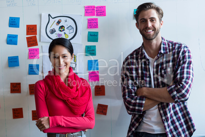 Colleagues standing against sticky notes in office