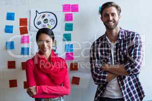 Colleagues standing against sticky notes in office