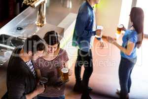 Woman showing mobile phone to boyfriend in bar
