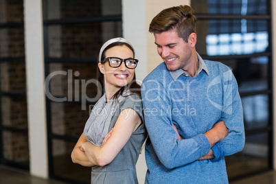 Colleagues standing with arms crossed in office