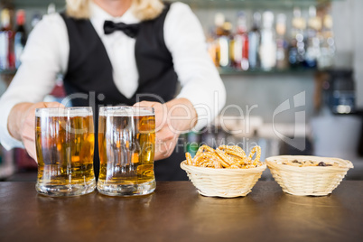 Close-up of man holding beer mug on the counter