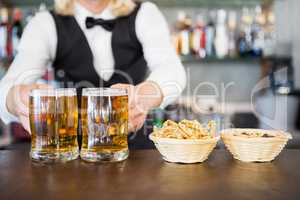 Close-up of man holding beer mug on the counter