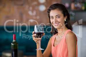 Smiling woman holding glass of red wine