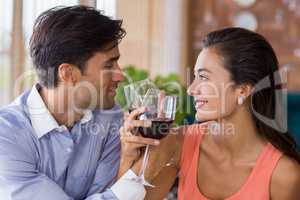 Couple toasting with arms crossed with a glass of wine