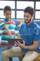 Teacher and school kid using digital table in library