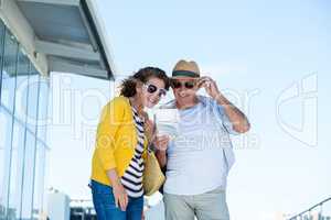 Couple with sunglasses reading map