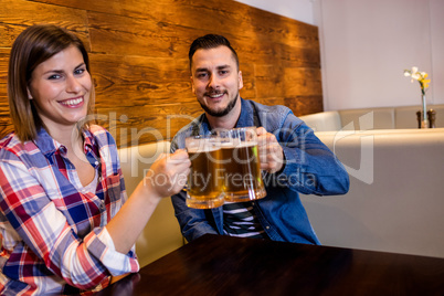 Cheerful couple toasting beer