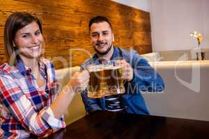 Cheerful couple toasting beer