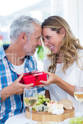 Romantic couple with gift in restaurant