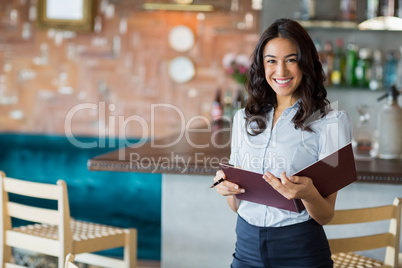 Smiling waitress holding a file Smiling waitress holding a file
