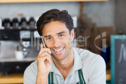 Portrait of waiter talking on mobile phone