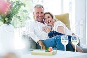 Happy romantic mature couple sitting on armchair