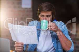 Businessman having coffee while reading document