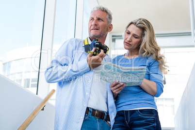 Mature couple reading map at home