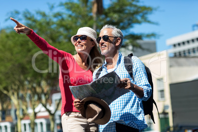 Woman pointing while standing by man in city
