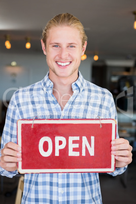 Man holding open signboard