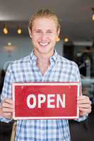 Man holding open signboard