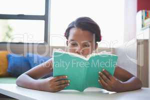 Schoolgirl reading book in library