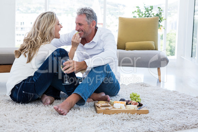 Happy woman feeding man at home