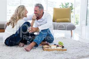 Happy woman feeding man at home