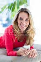Smiling woman using cellphone on seat
