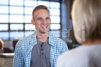 Creative businessman standing in front of female colleague
