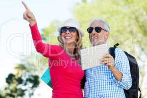 Happy couple looking away while holding digital tablet