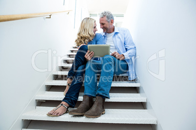 Full length of smiling couple using digital tablet